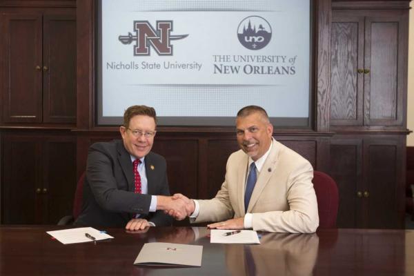 Nicholls State President Jay Clune and UNO President John Nicklow finalize a memorandum of understanding between the two universities at a signing ceremony on the Nicholls campus.