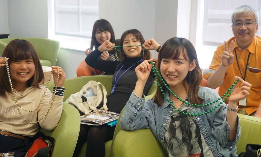 students holding mardi gras beads