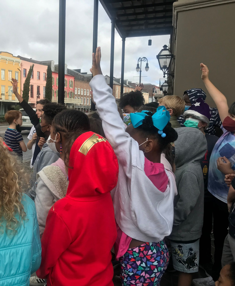 Students raising hands on field trip in the French Quarter