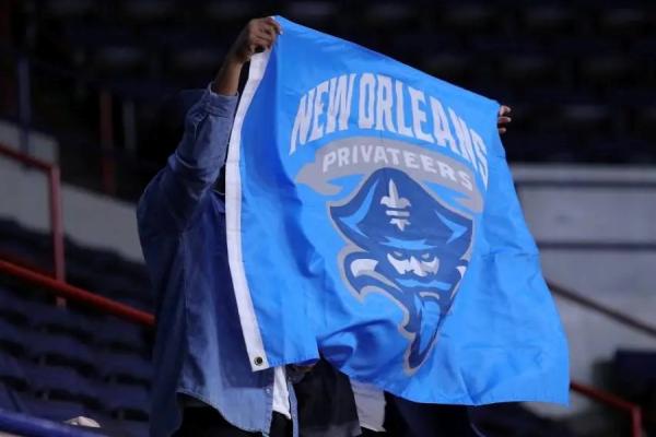 A fan holds up a flag with the Privateers logo