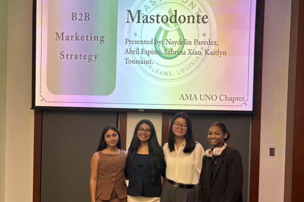 Four students under a screen reading "B2B Marketing Strategy - Mastodonte - AMA UNO Chapter".