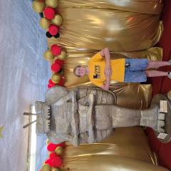 A student posing next to a large bug statue