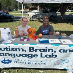 Students behind the Autism Brain and Language Lab table