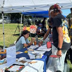 A student showing Bug Fest attendees how to do an activity