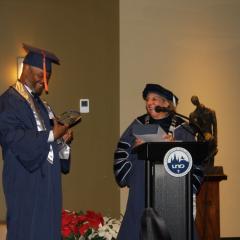 Dr. Kathy Johnson presents commencement speaker Mike Jackson with an award