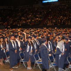 Students wave to their parents at graduation