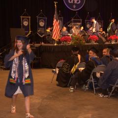 An excited graduate shows off their diploma
