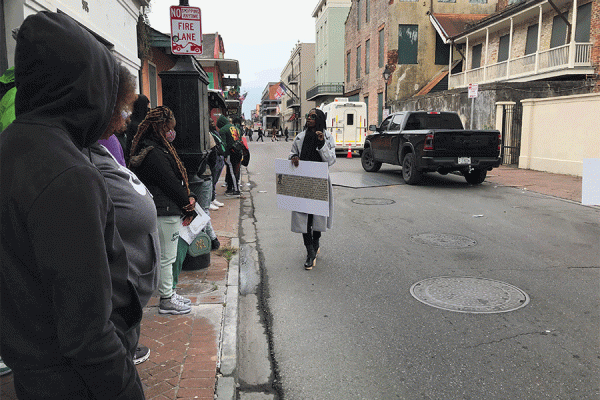 Students from The Living School on the “Displaced Tour” of the French Quarter with guide Shana Griffin, who is holding an advertisement from the Freedom on the Move database.