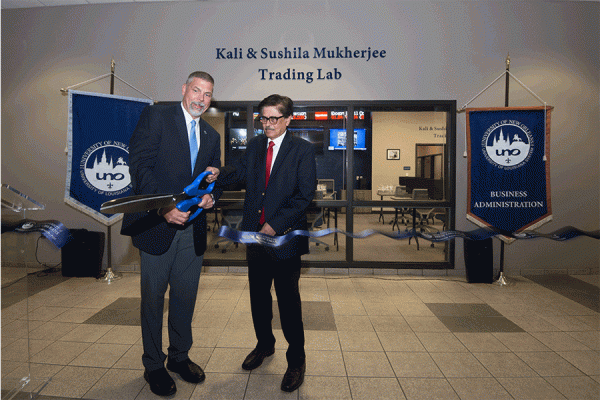 University of New Orleans President John Nicklow (left) and finance professor Tarun Mukherjee (right) cut the ribbon during a ceremony Wednesday for the opening of the Kali and Sushila Mukherjee Trading Lab that honors his parents. 