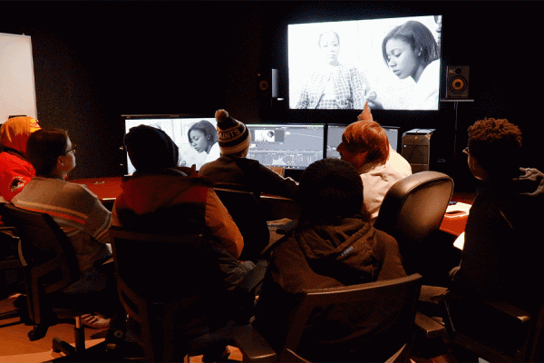 UNO professor James Roe (white jacket) talks with film students during a color correction class held in one of the upgraded computer finishing suites. Roe was the principal investigator for a state grant that funded upgrades.