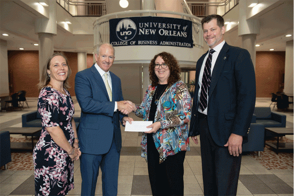 The Longo Group’s president, Ted Longo, presents a donation to Pamela Kennett-Hensel, dean of UNO’s College of Business Administration. They are pictured with Tracy Clanton (far left) and Eric Balukonis, major gifts officer with University Advancement.