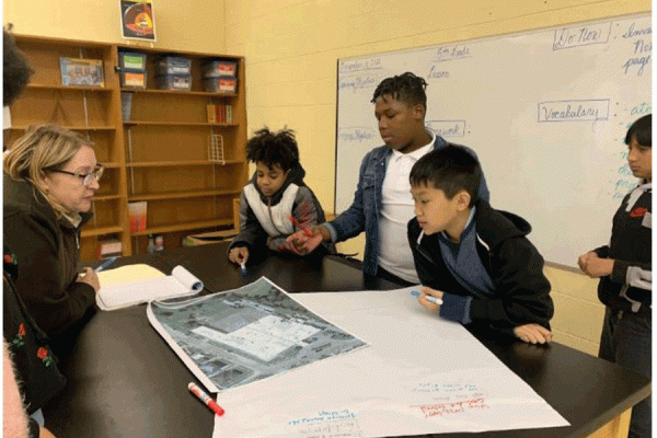 Students at Village de L’Est Elementary School work with Dianne Barth of U.S. Fish and Wildlife Service on solutions to issues they identified while surveying their school yard. 