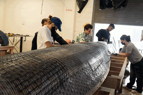 University of New Orleans engineering students layer a concrete mixture on the canoe they will race as part of the engineering competitions to be held at UNO during the American Society of Civil Engineers Gulf Coast Student Symposium. 